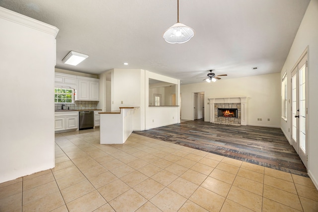 40614 Rolling Forest Dr, Magnolia, TX 77354 - unfurnished living room featuring light tile patterned flooring, ceiling fan, a tile fireplace, recessed lighting, and baseboards