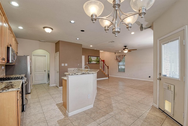 107 Cove W, Conroe, TX 77356 - kitchen with appliances with stainless steel finishes, light tile patterned floors, a ceiling fan, recessed lighting, and light stone counters