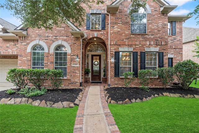 12415 Bunker Cove Dr, Cypress, TX 77433 - view of front of home featuring brick siding, a front yard, and a garage