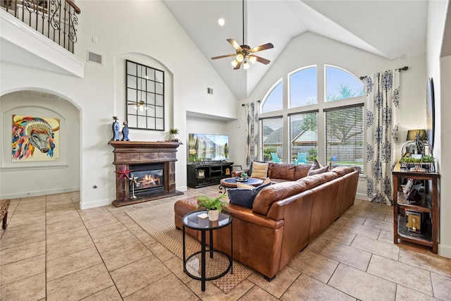 12415 Bunker Cove Dr, Cypress, TX 77433 - living room featuring a ceiling fan, high vaulted ceiling, a glass covered fireplace, baseboards, and tile patterned floors