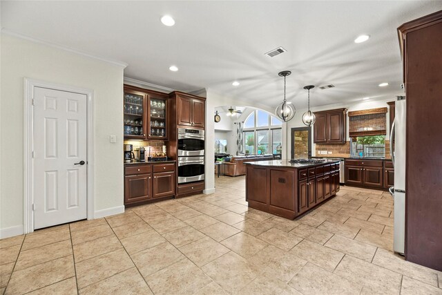 12415 Bunker Cove Dr, Cypress, TX 77433 - kitchen with decorative backsplash, appliances with stainless steel finishes, recessed lighting, dark brown cabinetry, and crown molding