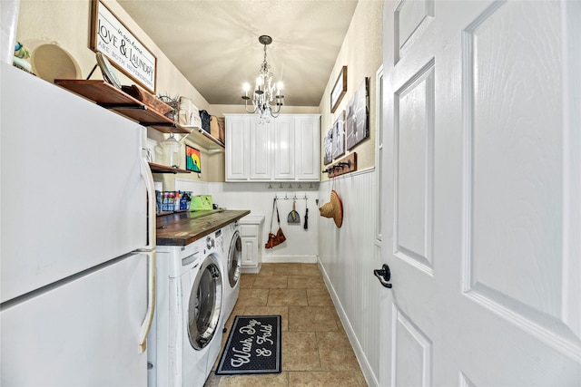 12415 Bunker Cove Dr, Cypress, TX 77433 - laundry area with washing machine and dryer, a chandelier, light stone finish flooring, and baseboards