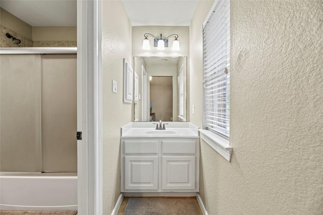 12415 Bunker Cove Dr, Cypress, TX 77433 - full bathroom featuring vanity, a textured wall, combined bath / shower with glass door, and baseboards