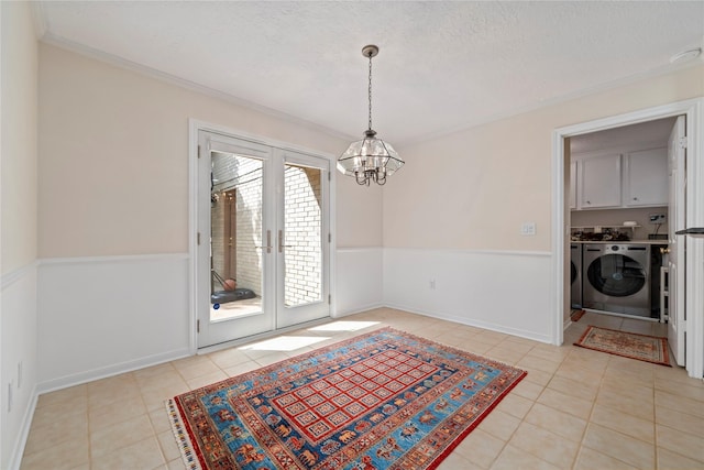 20611 Shillington Ct, Katy, TX 77450 - unfurnished dining area featuring washing machine and dryer, a chandelier, light tile patterned floors, crown molding, and french doors