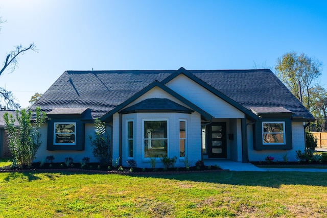 9219 Pecos St, Houston, TX 77055 - view of front of home with a front yard, a shingled roof, and brick siding