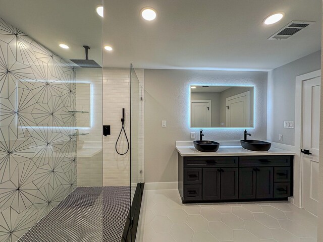 9219 Pecos St, Houston, TX 77055 - bathroom with tile patterned flooring, double vanity, a walk in shower, recessed lighting, and baseboards