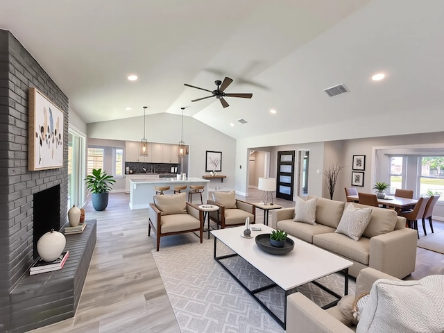 9219 Pecos St, Houston, TX 77055 - living room featuring lofted ceiling, light wood-type flooring, ceiling fan, a brick fireplace, and recessed lighting