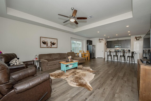 5766 Cerrillos Dr, Bryan, TX 77807 - living room with a tray ceiling, ceiling fan, wood finished floors, and recessed lighting