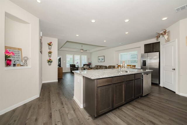 5766 Cerrillos Dr, Bryan, TX 77807 - kitchen featuring appliances with stainless steel finishes, dark wood-style flooring, a center island with sink, dark brown cabinetry, and ceiling fan