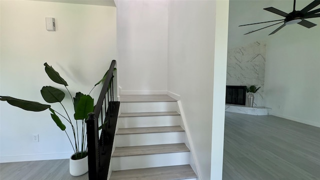 3311 Big Spruce Dr, Kingwood, TX 77339 - stairway with ceiling fan, wood finished floors, baseboards, and a fireplace