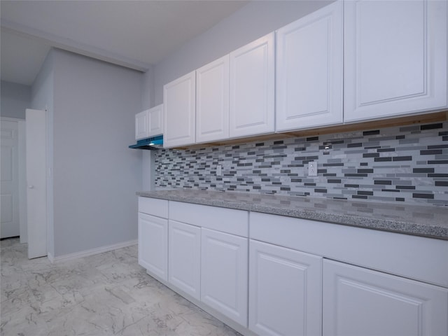 2703 Areba St, Houston, TX 77091 - kitchen with white cabinetry, light marble finish floors, tasteful backsplash, and light stone counters