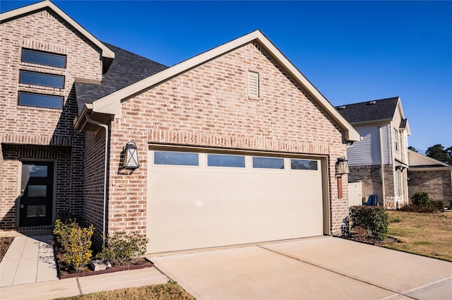 40575 Goldeneye Pl, Magnolia, TX 77354 - view of front of house featuring brick siding, an attached garage, driveway, and roof with shingles