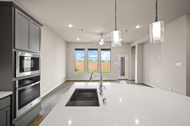 1963 Waters Branch Dr, Missouri City, TX 77459 - kitchen with stainless steel appliances, a sink, open floor plan, light countertops, and a ceiling fan