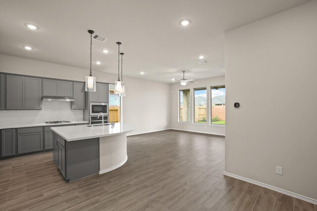 1963 Waters Branch Dr, Missouri City, TX 77459 - kitchen featuring gray cabinetry, a sink, stainless steel microwave, light countertops, and recessed lighting