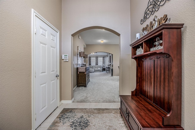 8406 Quiet Bay Dr, Baytown, TX 77523 - mudroom featuring arched walkways, light tile patterned floors, and light carpet