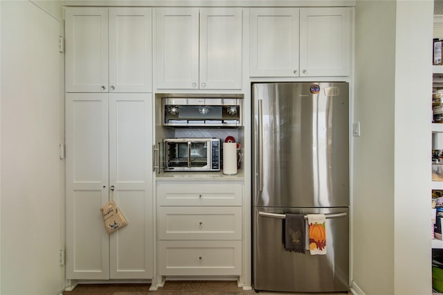 5001 Woodway Dr Unit 1405, Houston, TX 77056 - kitchen featuring freestanding refrigerator, light countertops, white cabinetry, and tasteful backsplash