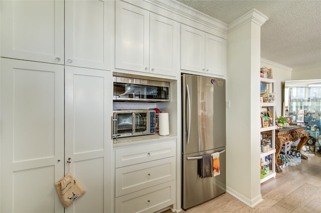 5001 Woodway Dr Unit 1405, Houston, TX 77056 - kitchen featuring freestanding refrigerator, a textured ceiling, crown molding, light wood-style floors, and light countertops