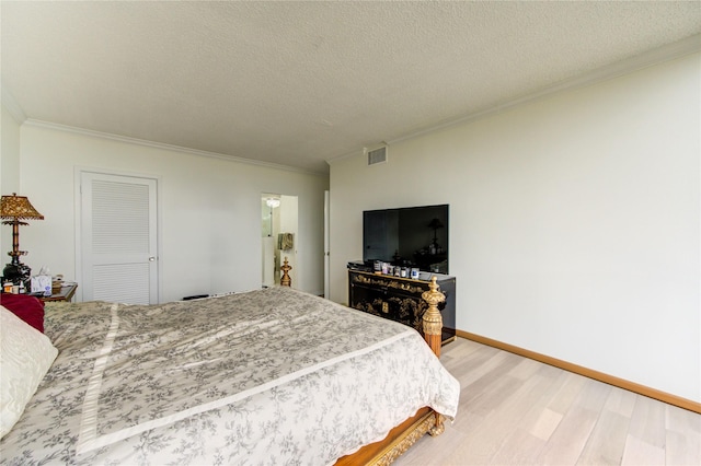 5001 Woodway Dr Unit 1405, Houston, TX 77056 - bedroom with crown molding, light wood-style flooring, baseboards, and a textured ceiling