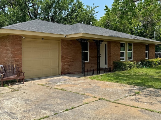 8117 Snowden St, Houston, TX 77028 - ranch-style home with brick siding, an attached garage, driveway, a front lawn, and roof with shingles