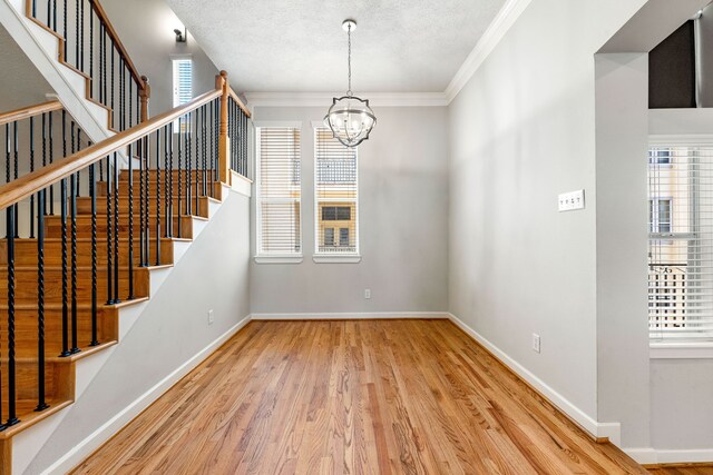 1333 W 21st St Unit B, Houston, TX 77008 - interior space featuring plenty of natural light, wood finished floors, a chandelier, crown molding, and a textured ceiling