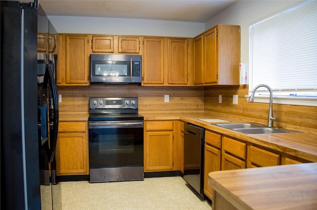 7331 Burkridge Dr, Houston, TX 77041 - kitchen with black appliances, a sink, light flooring, and brown cabinets