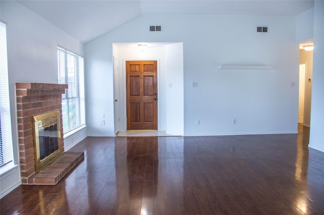 7331 Burkridge Dr, Houston, TX 77041 - unfurnished living room with dark wood-style flooring, lofted ceiling, a brick fireplace, and baseboards