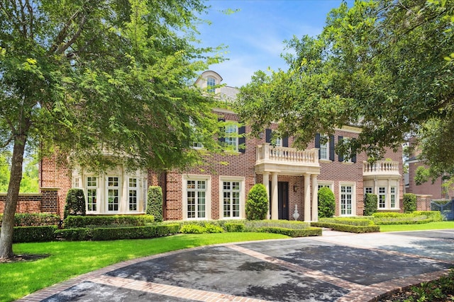 24 Farnham Park Dr, Houston, TX 77024 - colonial house featuring brick siding, a front yard, uncovered parking, and a balcony