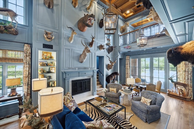24 Farnham Park Dr, Houston, TX 77024 - living area with a towering ceiling, healthy amount of natural light, a fireplace with flush hearth, coffered ceiling, and hardwood / wood-style floors