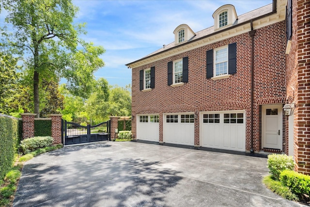 24 Farnham Park Dr, Houston, TX 77024 - view of home's exterior featuring driveway, a gate, a garage, and brick siding