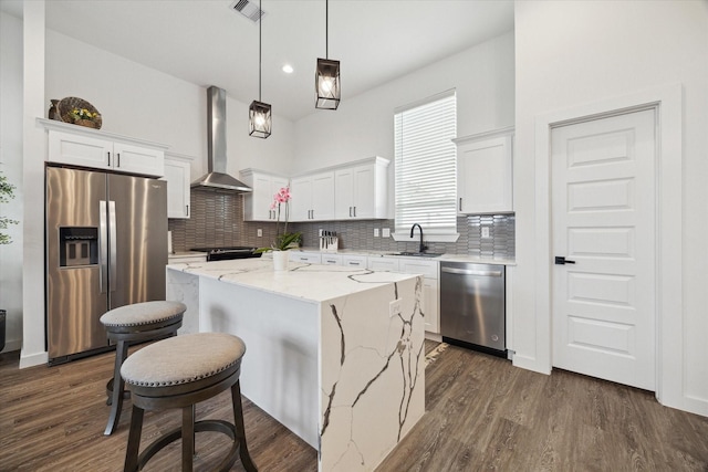 306 W Donovan St, Houston, TX 77091 - kitchen with stainless steel appliances, wall chimney range hood, a sink, backsplash, and white cabinetry