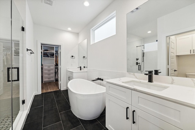 306 W Donovan St, Houston, TX 77091 - bathroom with a stall shower, a walk in closet, vanity, a freestanding tub, and tile patterned floors