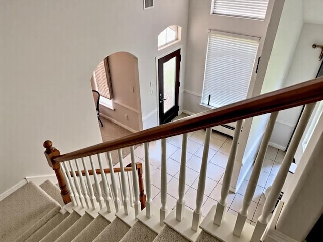 2914 Renoir, Sugar Land, TX 77479 - stairs featuring arched walkways, baseboards, carpet, a towering ceiling, and a baseboard heating unit