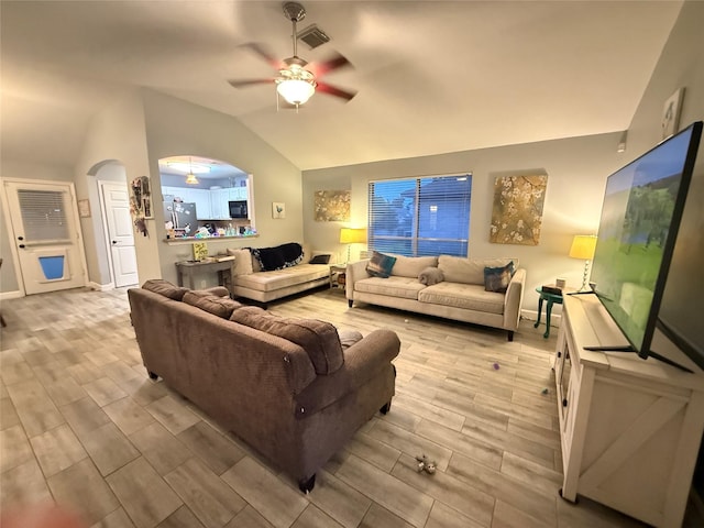 207 Leisure Ln, Montgomery, TX 77356 - living room featuring vaulted ceiling, a ceiling fan, wood finish floors, arched walkways, and baseboards