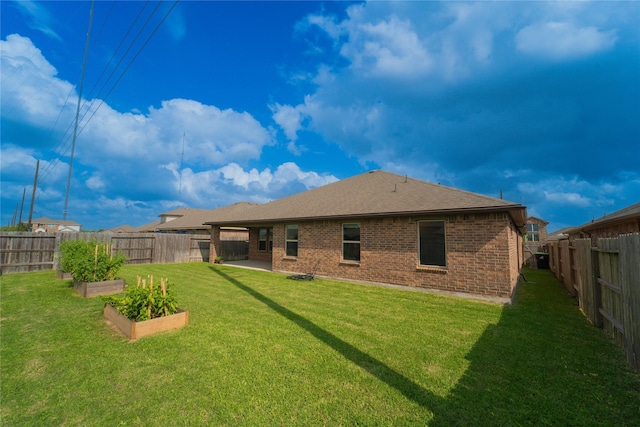 1318 Bellingham Park Dr, Missouri City, TX 77459 - back of property with a garden, brick siding, a shingled roof, and a patio