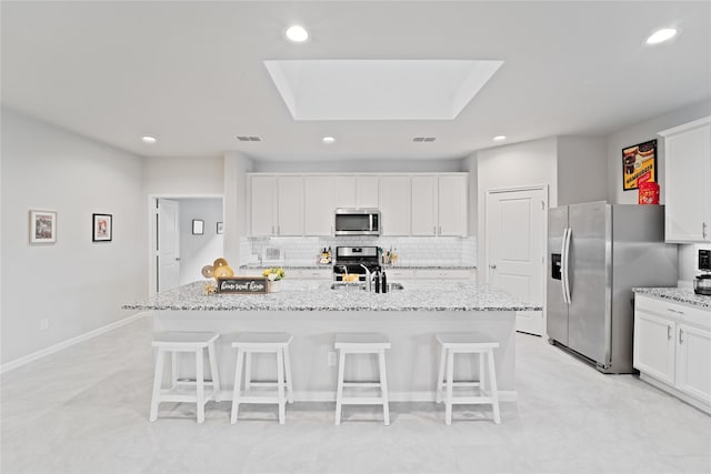 1318 Bellingham Park Dr, Missouri City, TX 77459 - kitchen with appliances with stainless steel finishes, a kitchen breakfast bar, decorative backsplash, a center island with sink, and recessed lighting