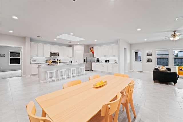 1318 Bellingham Park Dr, Missouri City, TX 77459 - dining area with recessed lighting, light tile patterned floors, a skylight, a ceiling fan, and baseboards