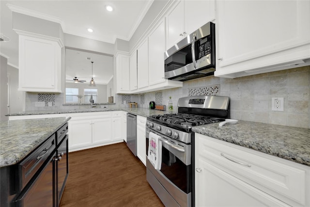 2609 Riverside Dr Unit C, Houston, TX 77004 - kitchen featuring stainless steel appliances, a sink, ornamental molding, dark wood finished floors, and white cabinetry