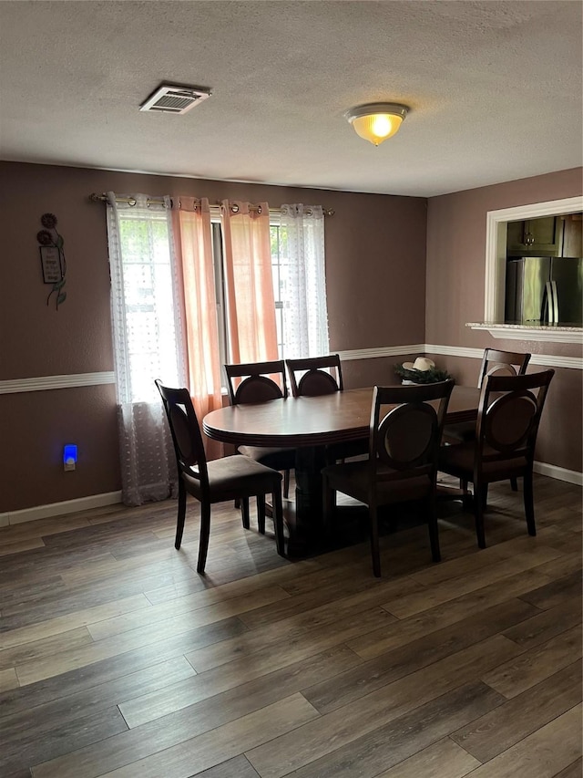 309 Aycock St, Clute, TX 77531 - dining room featuring plenty of natural light, a textured ceiling, dark wood-style floors, and baseboards