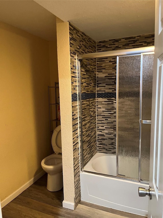 309 Aycock St, Clute, TX 77531 - full bathroom with toilet, wood finished floors, combined bath / shower with glass door, and baseboards