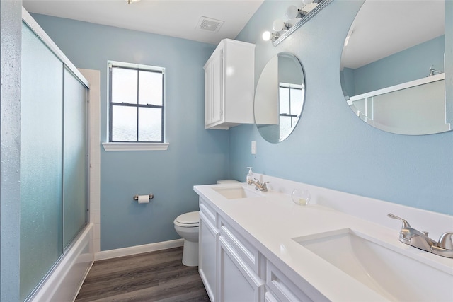 1402 Osborne Dr, Friendswood, TX 77546 - full bathroom with toilet, wood finished floors, double vanity, baseboards, and enclosed tub / shower combo