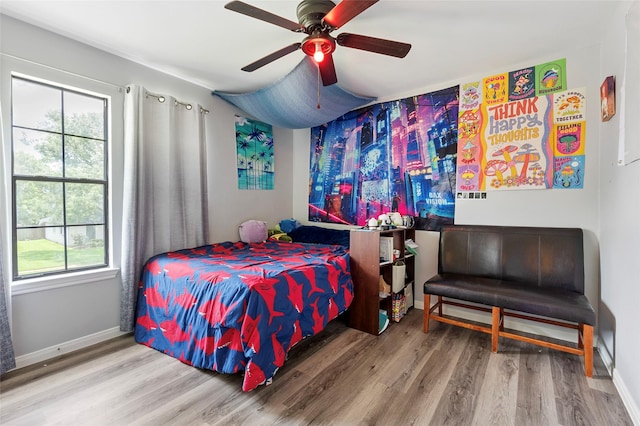 1402 Osborne Dr, Friendswood, TX 77546 - bedroom featuring wood finished floors, multiple windows, baseboards, and a ceiling fan