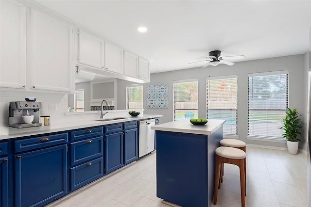1402 Osborne Dr, Friendswood, TX 77546 - kitchen featuring a sink, blue cabinetry, dishwasher, a ceiling fan, and white cabinetry