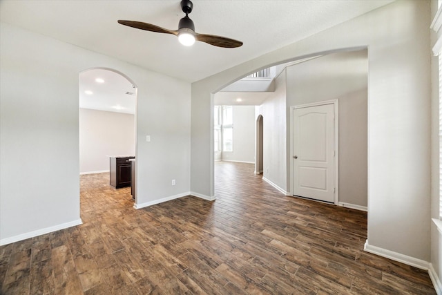 19426 Blueberry Cedar Dr, Cypress, TX 77433 - empty room featuring arched walkways, ceiling fan, dark wood-type flooring, and baseboards