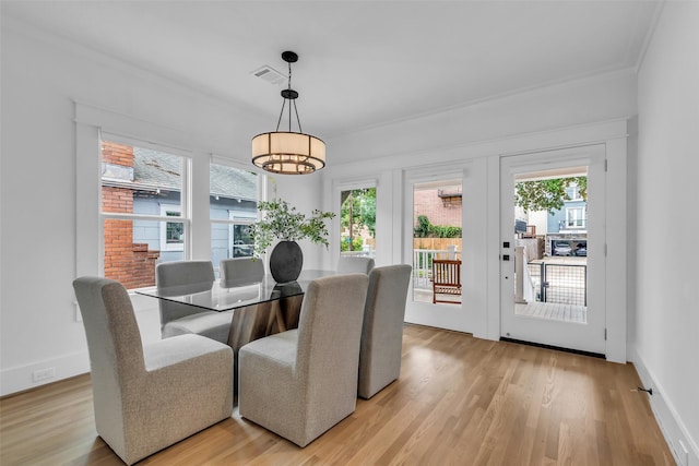 904 Willard St, Houston, TX 77006 - dining area featuring plenty of natural light, crown molding, light wood-type flooring, and a chandelier