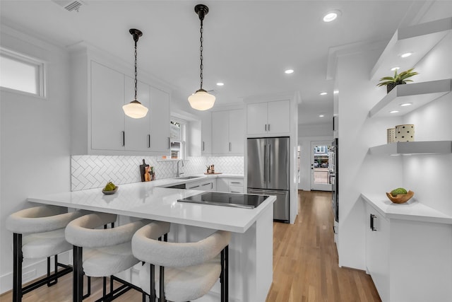 904 Willard St, Houston, TX 77006 - kitchen featuring appliances with stainless steel finishes, a sink, a peninsula, backsplash, and light countertops