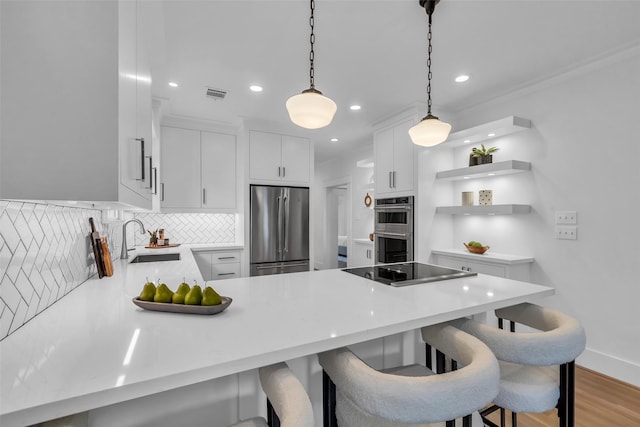 904 Willard St, Houston, TX 77006 - kitchen featuring stainless steel appliances, a sink, a peninsula, light countertops, and tasteful backsplash