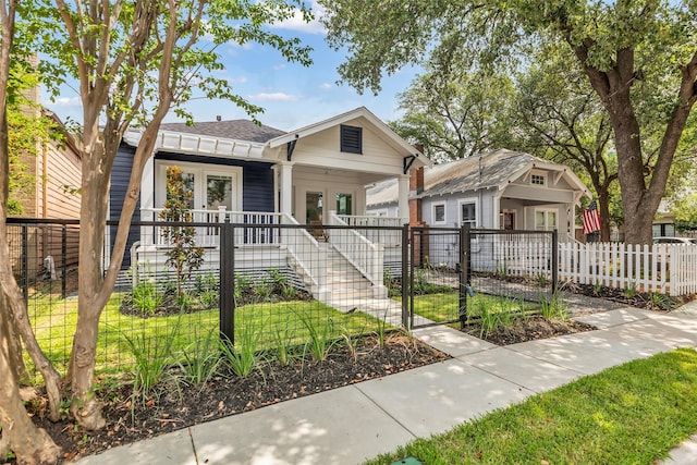 904 Willard St, Houston, TX 77006 - view of front facade with covered porch, a fenced front yard, a gate, french doors, and stairs