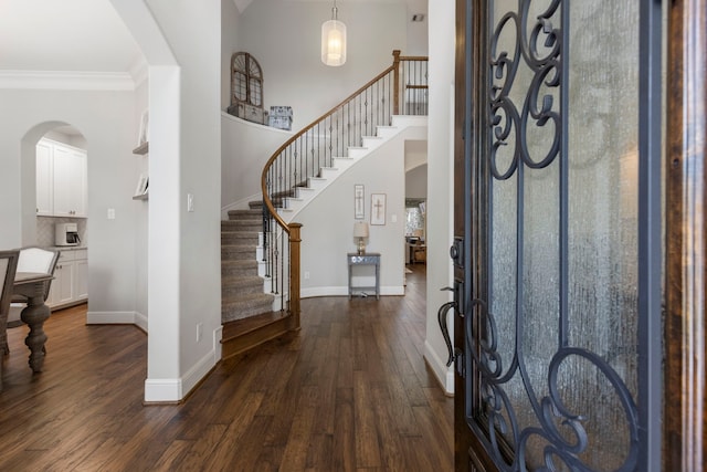 2678 Granite River Ln, Conroe, TX 77385 - entryway with arched walkways, dark wood finished floors, baseboards, stairs, and ornamental molding