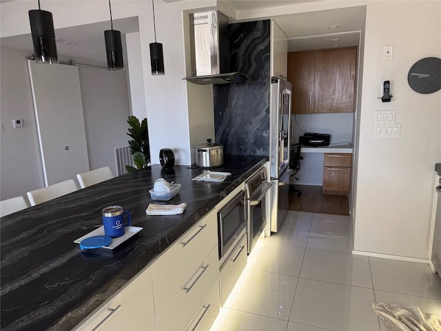 49 Briar Hollow Ln Unit 1201, Houston, TX 77027 - kitchen with wall chimney range hood, light tile patterned flooring, stainless steel appliances, dark countertops, and modern cabinets