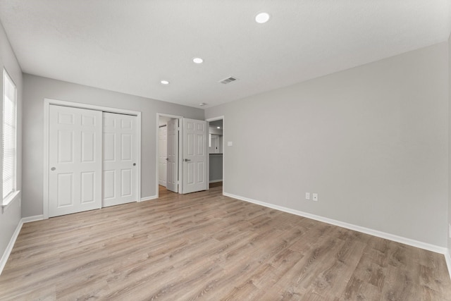 235 E Rainbow Ridge Cir, The Woodlands, TX 77381 - unfurnished bedroom featuring multiple windows, light wood-style floors, and recessed lighting